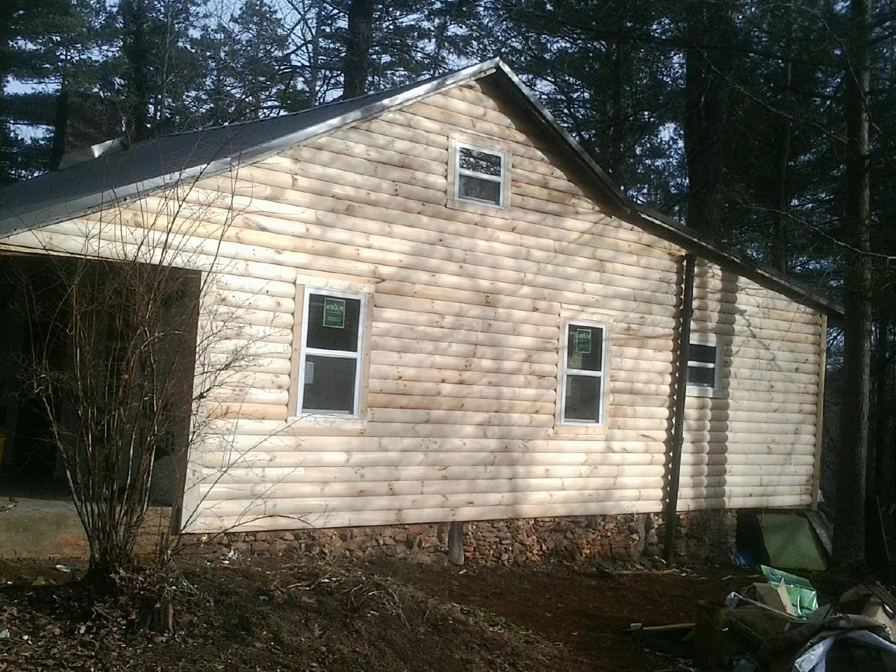 New log siding and dark metal roofing on a gable end in Overland Park