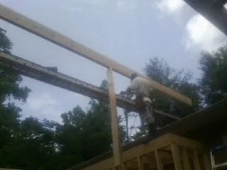Carpenter setting a ridge beam over a new addition frame — Ice Dam Removal by Roofing Brothers in Overland Park