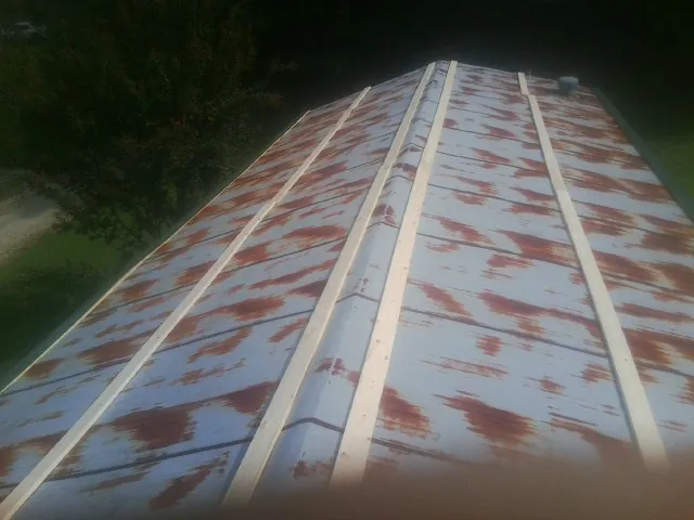 Rusted metal roof panels with new wood purlins before replacement — Storm Damage Roof Repair in Overland Park by Roofing Brothers