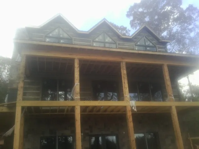Dormers and porch framing on a large log home under construction — Roof Coating work by our crew in Overland Park