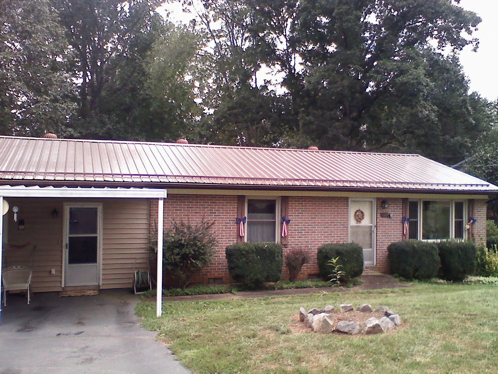 Bronze metal roof and carport on a brick ranch home — Roof Repair work by our crew in Overland Park